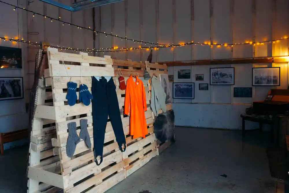 Indoor exhibition space with clothing displayed on pallets
