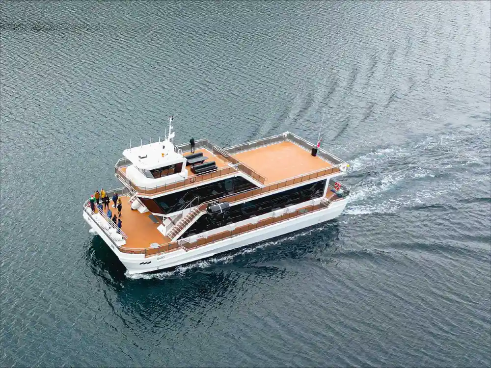 Luxury motor yacht cruising on blue water with orange deck